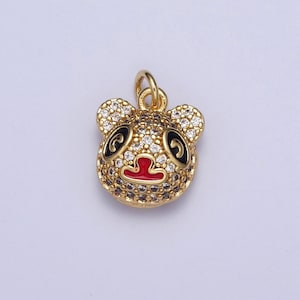 Puede incluir: Encanto de tono dorado con diseño de oso panda con ojos negros, nariz roja y detalles en blanco y negro. El encanto está adornado con diamantes de imitación transparentes.
