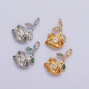 May include: Four silver and gold rose flower charms with clear and green gemstones. The charms are perfect for jewelry making.