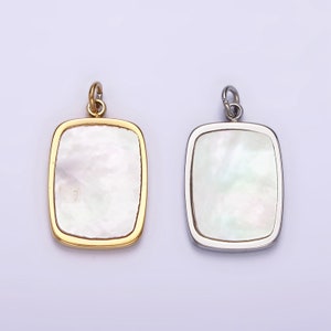 May include: Two square-shaped pendants with a white mother-of-pearl inlay. One pendant has a gold frame and the other has a silver frame.