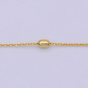 May include: A gold chain necklace with a single, round, gold bead pendant.