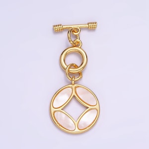 May include: Gold-tone toggle clasp with a round, white mother-of-pearl pendant featuring a geometric design.