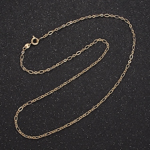 May include: A gold chain necklace with a lobster clasp closure. The chain is made of small, oval-shaped links.