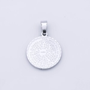 May include: Silver pendant with a circular design featuring the Hail Mary prayer in a spiral pattern.