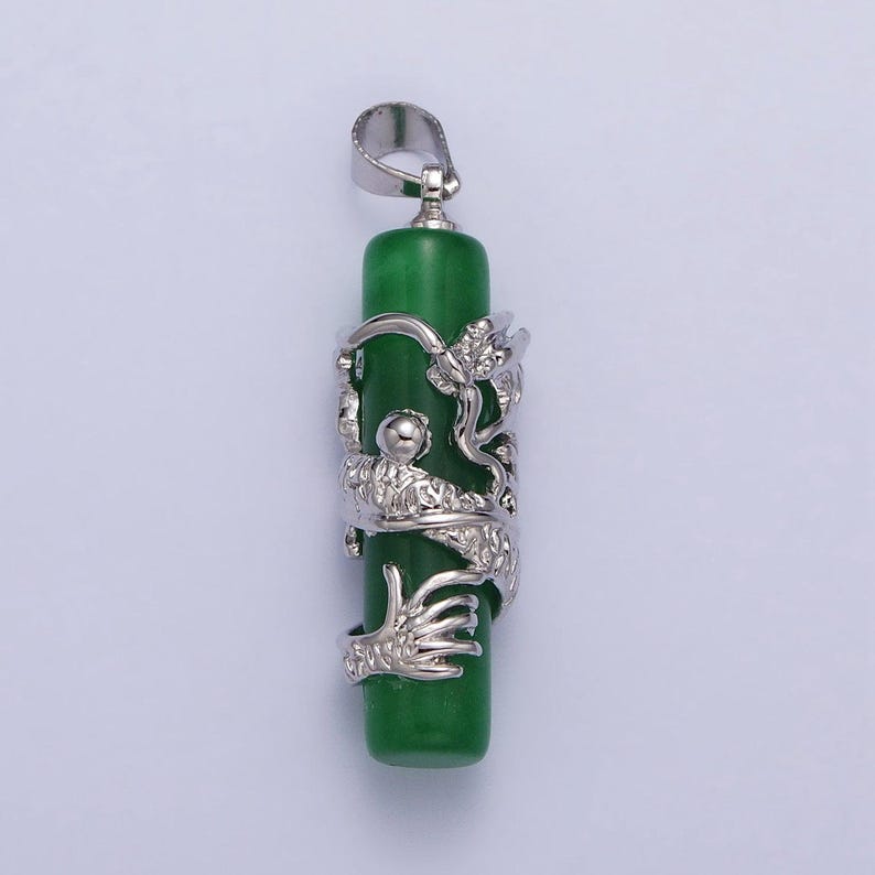 Op de afbeelding: Een zilveren drakenhanger met een groene jade-steen. De draak is om de steen gewikkeld, en de hanger heeft een zilveren lus.