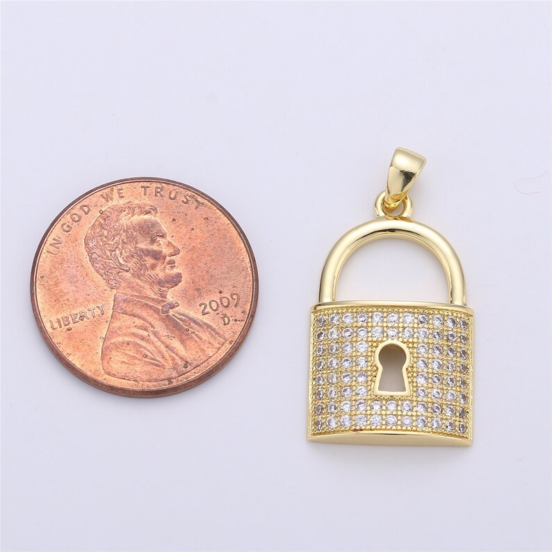 Pu&ograve; includere: Ciondolo a forma di lucchetto dorato con pietre di zircone cubico trasparenti. Il ciondolo &egrave; circa delle dimensioni di una moneta da un centesimo di euro.