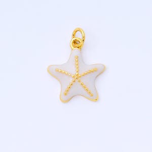 May include: A gold-colored starfish pendant with a white enamel center and gold beaded accents. The pendant has a loop at the top for attaching to a chain or bracelet. The starfish design is a popular nautical theme.
