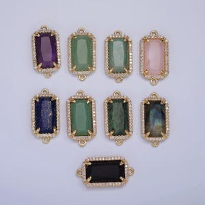 Könnte beinhalten: Acht goldfarbene rechteckige Verbindungsanhänger mit verschiedenen Edelsteinen und einem klaren Kristallrand. Die Anhänger haben oben und unten zwei Schlaufen zum Anbringen an Schmuck.