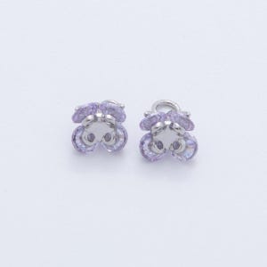 May include: A pair of small, flower-shaped earrings. Each earring features a cluster of light purple, faceted crystals set in a silver-colored metal. The earrings have a post and loop design.