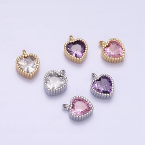 May include: Six heart-shaped charms with different colored rhinestones. The charms are gold and silver with a beaded border.