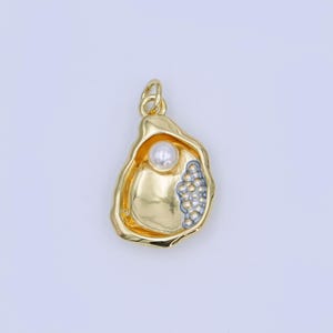 May include: A gold-coloured oyster shell pendant with a pearl inside. The pendant has a textured surface and a cluster of small, silver-coloured beads on one side. The bail is also gold-coloured.