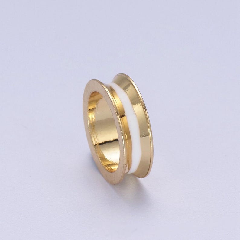 Peut inclure: Une bague en or avec une bande en &eacute;mail blanc. La bague est de conception simple avec une finition lisse.
