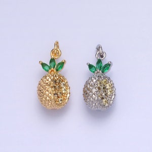May include: Two gold and silver pineapple charms with green leaves and clear rhinestones. The charms are perfect for adding a touch of tropical flair to jewelry.
