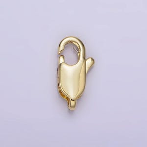 May include: Gold-toned metal lobster clasp for jewelry making. The clasp is a simple, functional design with a smooth finish.