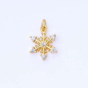 以下が含まれることがあります： 金色で、6つの透明な丸いクリスタルが付いた雪の結晶チャーム。チャームの上部には、ネックレスやブレスレットに取り付けるためのループが付いています。雪の結晶のデザインは繊細で、冬をテーマにしたジュエリーに最適です。