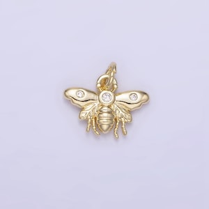 May include: A gold bee charm with clear crystal accents. The bee has detailed wings and a textured body.