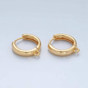 May include: A pair of gold-toned hoop earrings with a jump ring attached to each hoop.
