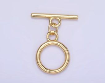 May include: Gold-toned metal toggle clasp with a round ring. The clasp is designed for attaching to a strap or chain.