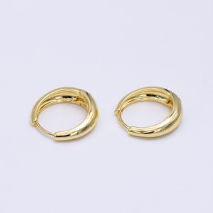 Peut inclure: Une paire de boucles d'oreilles créoles en or. Les boucles d'oreilles sont simples et élégantes, avec une finition lisse et arrondie.
