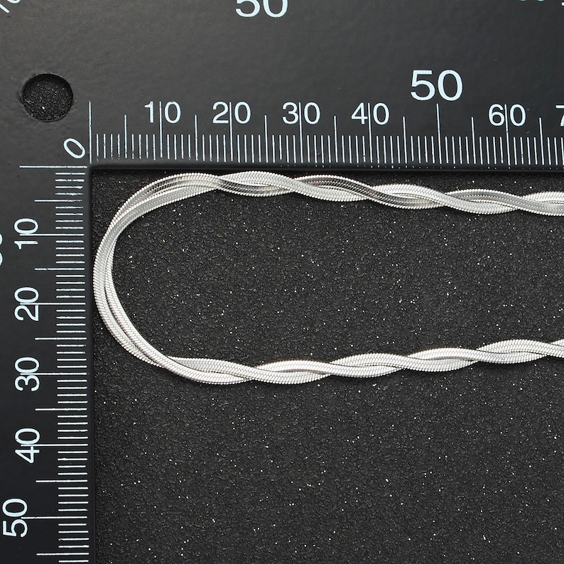 May include: A silver snake chain necklace measuring 50 inches in length. The chain is made of a series of small, interlocking links that create a smooth, flowing look.