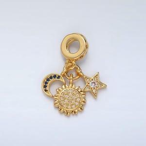 May include: Gold charm with a sun, moon, and star design. The sun and star are encrusted with clear crystals, and the moon has blue crystals.
