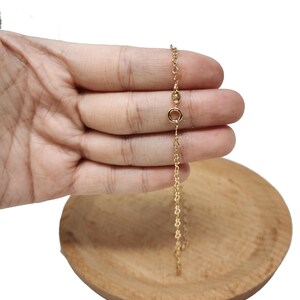 Op de afbeelding: Een gouden ketting met een karabijn sluiting.