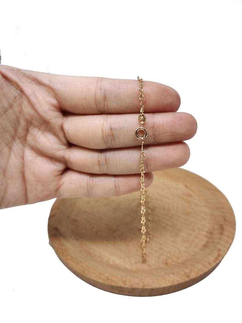 Op de afbeelding: Een gouden ketting met een karabijn sluiting.