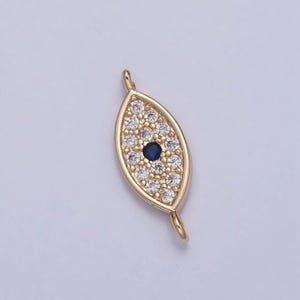 Può includere: Ciondolo portafortuna a forma di occhio turco dorato con centro blu e dettagli in cristallo trasparente. Il ciondolo è a forma di mandorla e ha un anello in alto per essere attaccato ai gioielli.
