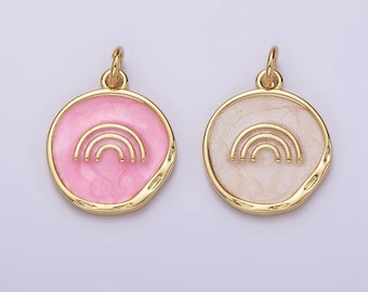 Puede incluir: Dos colgantes de tono dorado con un diseño de arcoíris. Un colgante tiene un fondo de esmalte rosa y el otro tiene un fondo de esmalte blanco.