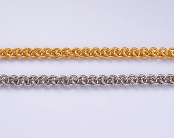 Peut inclure: Gros plan de deux chaînes métalliques. La chaîne supérieure est de couleur or et la chaîne inférieure est de couleur argent. Les deux chaînes ont un motif tissé. Les chaînes sont affichées sur un fond blanc.