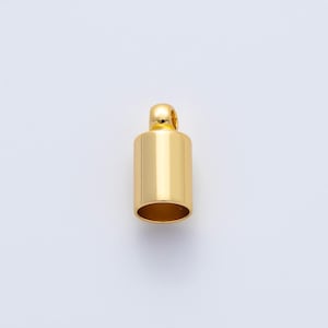 May include: A gold-colored cylindrical jewelry finding with a rounded top and a small loop. The bottom opening is visible, and the piece has a polished, reflective surface. The item is set against a plain white background.