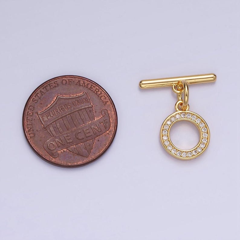 Pode incluir: Fecho de correr dourado com um pingente redondo incrustado com strass transparentes. O pingente &eacute; aproximadamente do tamanho de uma moeda de um centavo de d&oacute;lar americano.