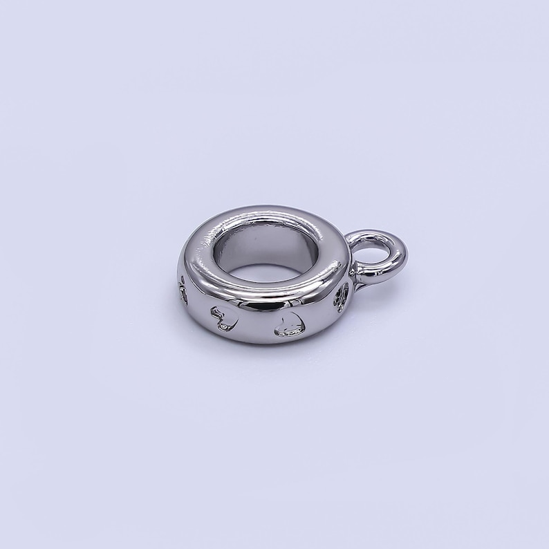 May include: A shiny, silver-colored charm with a circular design and a small loop. The charm has heart-shaped cutouts around the outer edge. This jewelry component is suitable for necklaces, bracelets, and other DIY jewelry projects.