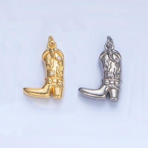 May include: Two silver and gold cowboy boot charms with a detailed design and rhinestones.