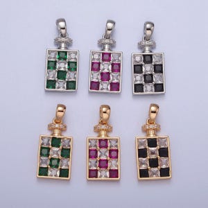 May include: Six silver and gold pendant charms with a square checkerboard design. The charms feature green, red, and black cubic zirconia stones.