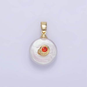 May include: A gold pendant featuring a white pearl with a small red gemstone set in the center.