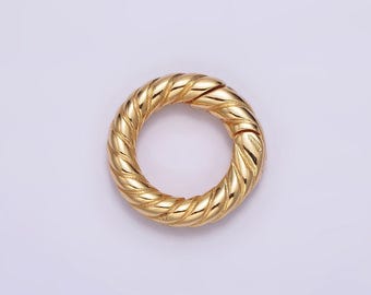 May include: A gold-toned metal ring with a twisted rope design. The ring is open and has a smooth, polished finish.