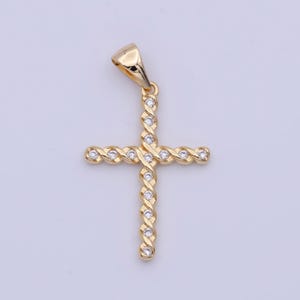 May include: A gold-tone cross pendant with clear cubic zirconia stones set in a twisted design.