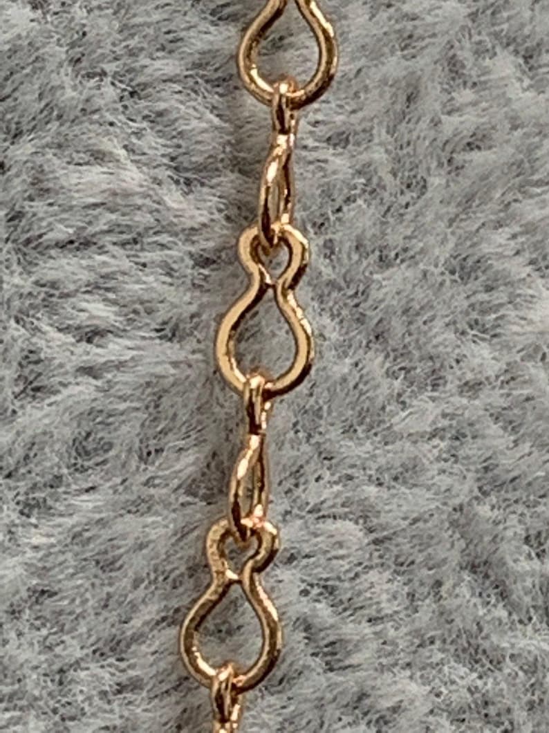 Op de afbeelding: Close-up van een gouden ketting met een delicaat, figuur-acht schakels ontwerp.