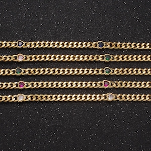 Könnte beinhalten: Fünf goldene Kettenarmbänder mit unterschiedlichfarbigen herzförmigen Edelsteinen. Die Edelsteine sind blau, rosa, grün, rot und klar.