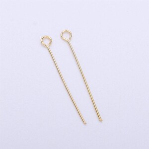 以下が含まれることがあります： 上部にループが付いた金色のヘッドピンが2本。ヘッドピンは約5cmの長さです。