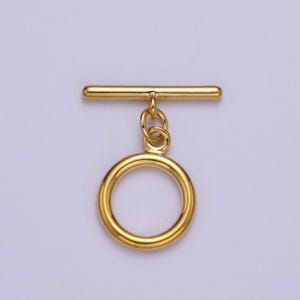May include: Gold-toned metal toggle clasp with a round ring. The clasp is designed for attaching to a necklace, bracelet, or other jewelry.
