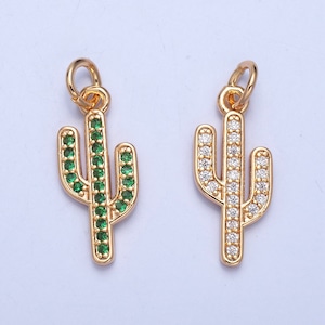 May include: Two gold cactus charms with crystal accents. One charm has green crystals and the other has clear crystals.