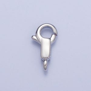 May include: Silver-toned lobster clasp with a spring-loaded mechanism. The clasp is designed for attaching jewellery or other items.