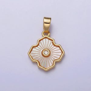 May include: Gold pendant with a white, iridescent, geometric design and a small clear rhinestone in the center.