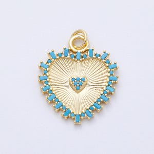 May include: Gold-colored heart-shaped pendant with a turquoise blue gemstone border. The pendant has a textured, sunburst design and a small heart in the center. The pendant is designed for jewelry making.
