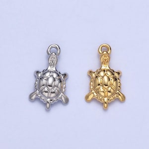 May include: Two turtle charms, one silver and one gold, with detailed shell designs.