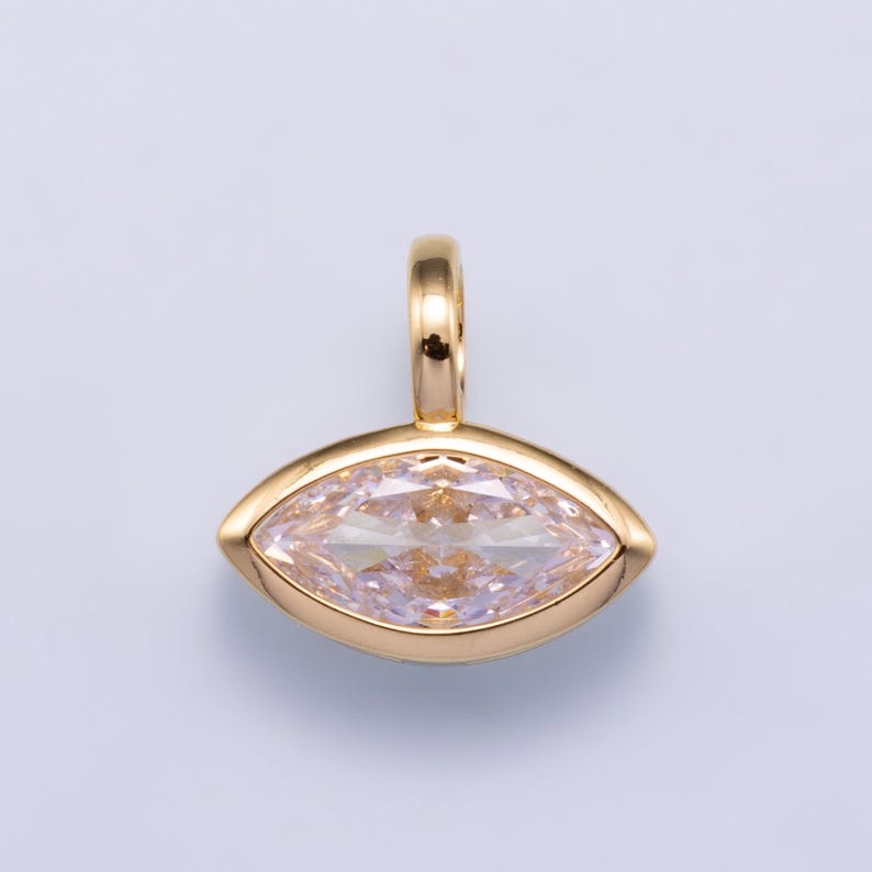 May include: A gold pendant featuring a marquise-cut, light pink gemstone set in a smooth, polished gold bezel. The pendant includes a small, rounded gold bail at the top for attachment to a chain, showcasing a clean and symmetrical design.