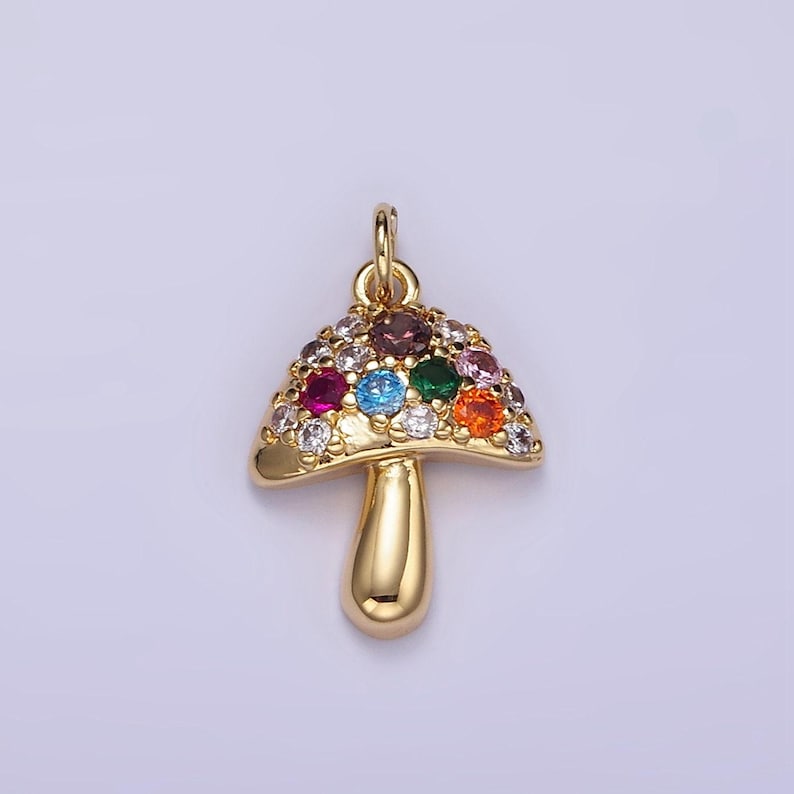 May include: A gold-tone mushroom charm with colorful crystal accents. The charm is perfect for adding a whimsical touch to jewelry projects.