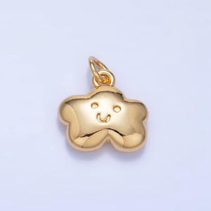 May include: Gold-colored charm shaped like a cloud with a smiling face. The charm has a loop at the top for attaching to a necklace or bracelet.