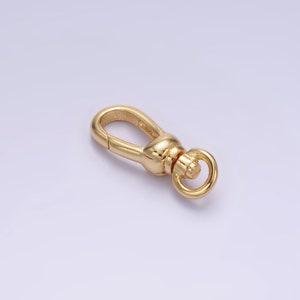 May include: Gold-toned metal clasp with a spring-loaded gate and a round ring. The clasp is designed for attaching to a strap or chain.